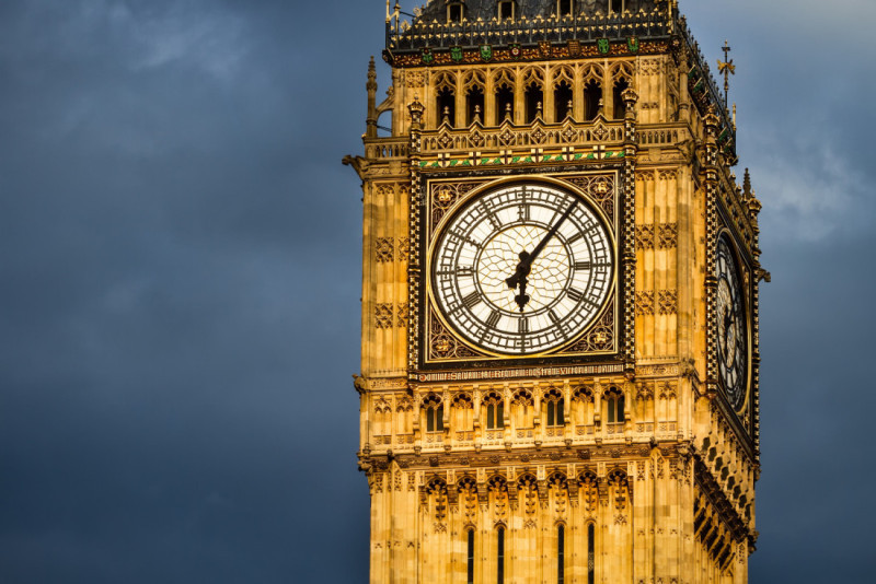 The iconic Big Ben clock tower stands against a dramatic sky, showcasing its intricate architectural details and the striking clock face.