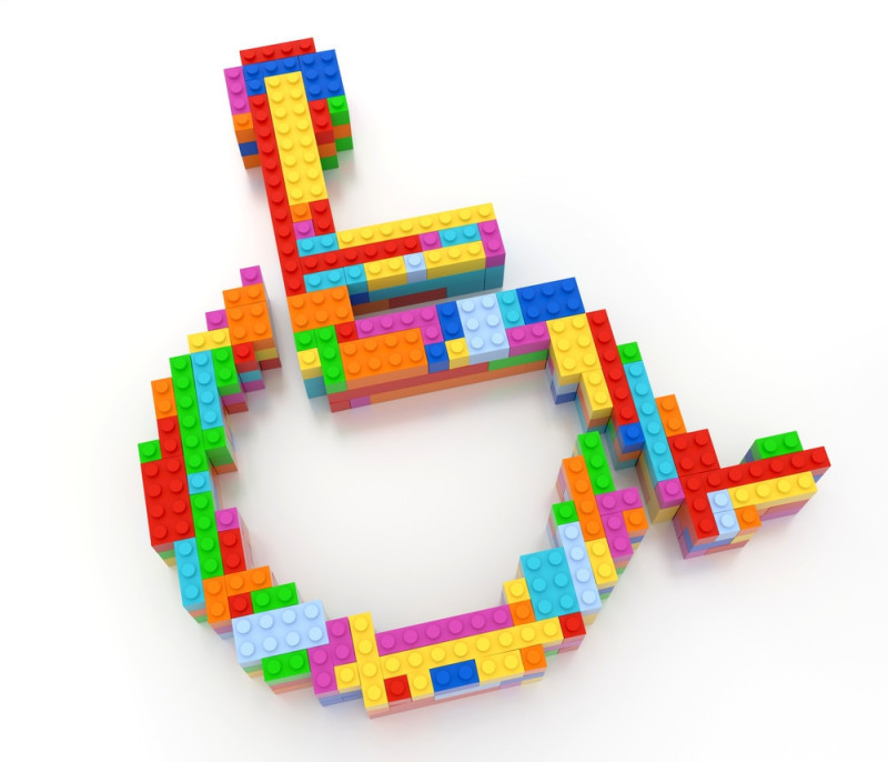 Colorful building blocks arranged to form the universal accessibility symbol, resembling a wheelchair icon.