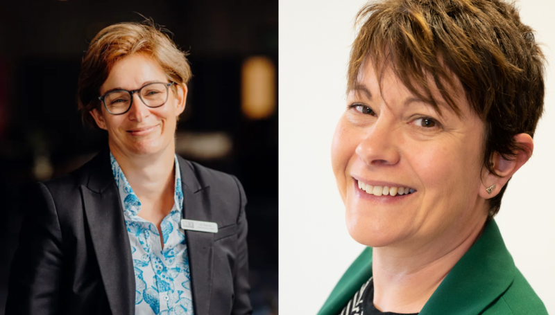 Two professional women are smiling at the camera. The woman on the left has short brown hair, glasses, and is wearing a black blazer over a patterned blue shirt. The woman on the right has lighter, textured short hair and is wearing a green blazer over a striped shirt. Both seem confident and approachable.
