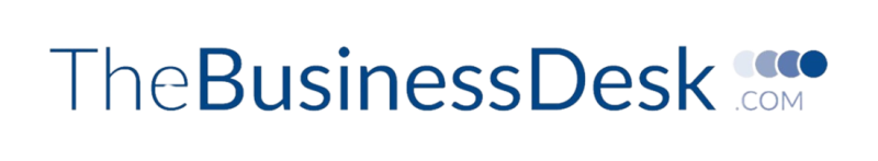 The logo for TheBusinessDesk.com, featuring a blue text with a modern design and circular accents.