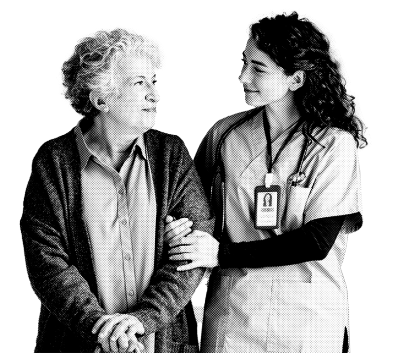 A caregiver in scrubs gently supports an elderly woman with curly hair, both smiling and sharing a warm moment together.