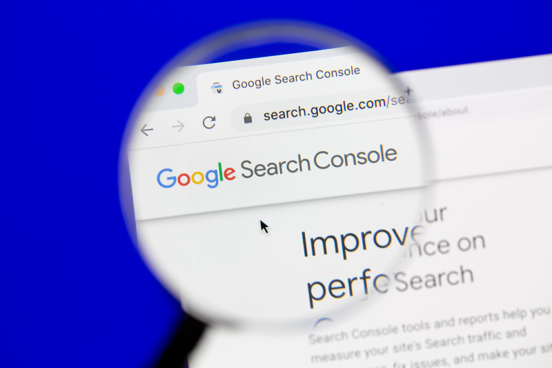 Google Search Console webpage displayed in a browser window, magnified by a lens. The text "Improve your performance on Search" is visible below the logo.